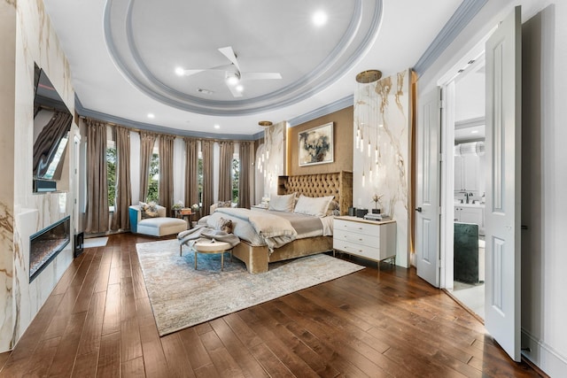 5006 Water View Bnd, Sugar Land, TX 77479 - bedroom featuring a raised ceiling, ornamental molding, dark wood finished floors, and a premium fireplace