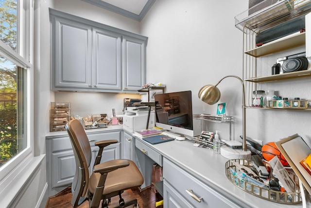 office space with built in desk and crown molding