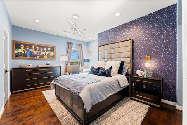 bedroom featuring baseboards, dark wood finished floors, visible vents, and wallpapered walls