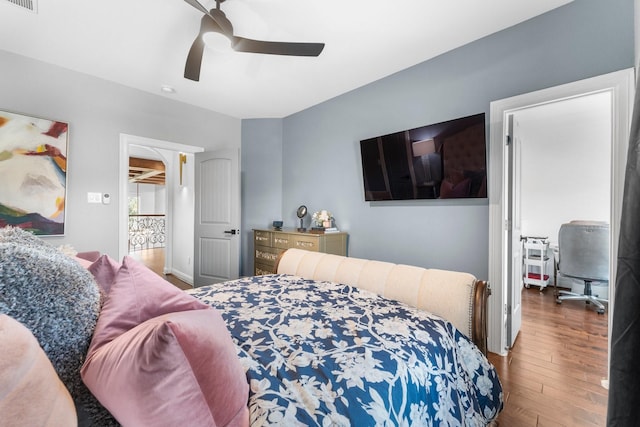 bedroom featuring wood finished floors, visible vents, and a ceiling fan