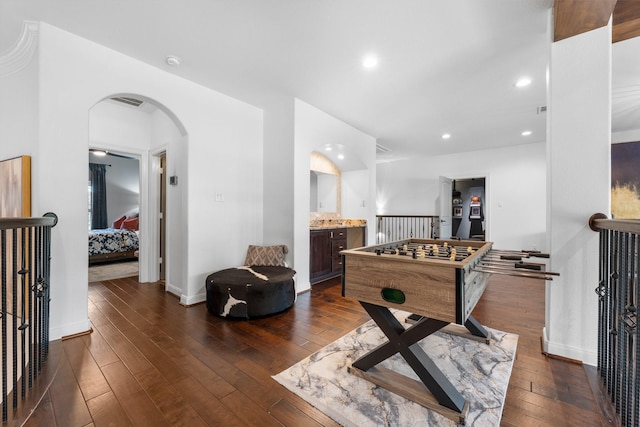 playroom featuring wood-type flooring, arched walkways, baseboards, and recessed lighting