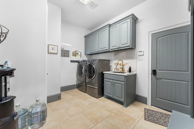 laundry area with cabinet space, visible vents, washing machine and dryer, a sink, and baseboards