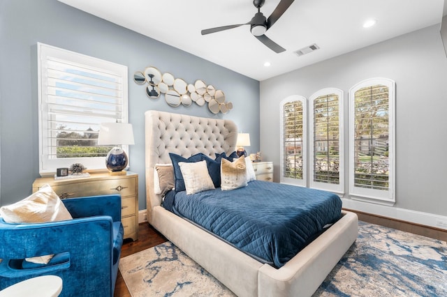 bedroom featuring wood finished floors, visible vents, and baseboards