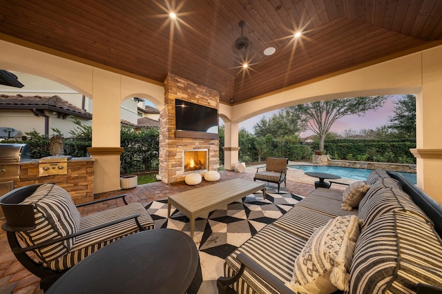 view of patio featuring an outdoor living space with a fireplace, area for grilling, exterior kitchen, and an outdoor pool