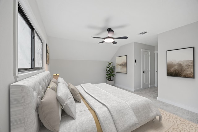 bedroom featuring visible vents, ceiling fan, baseboards, light colored carpet, and vaulted ceiling