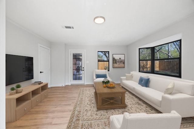 living area featuring light wood-style flooring, baseboards, and visible vents