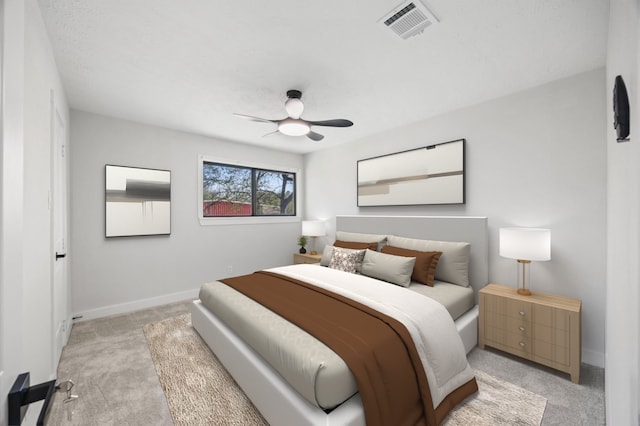 bedroom with visible vents, baseboards, light colored carpet, and ceiling fan