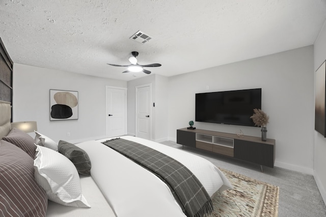 bedroom with a ceiling fan, baseboards, visible vents, carpet floors, and a textured ceiling