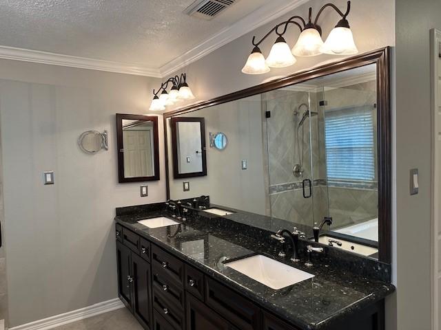 full bath featuring crown molding, visible vents, a sink, and a shower stall