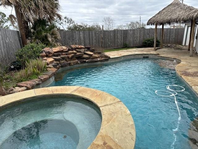 view of pool with an in ground hot tub, a gazebo, a fenced backyard, and a fenced in pool