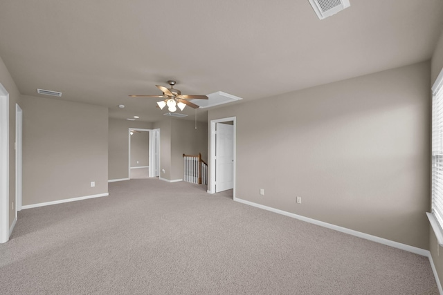 empty room with attic access, visible vents, baseboards, and carpet flooring