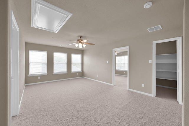 empty room featuring light carpet, visible vents, attic access, and baseboards