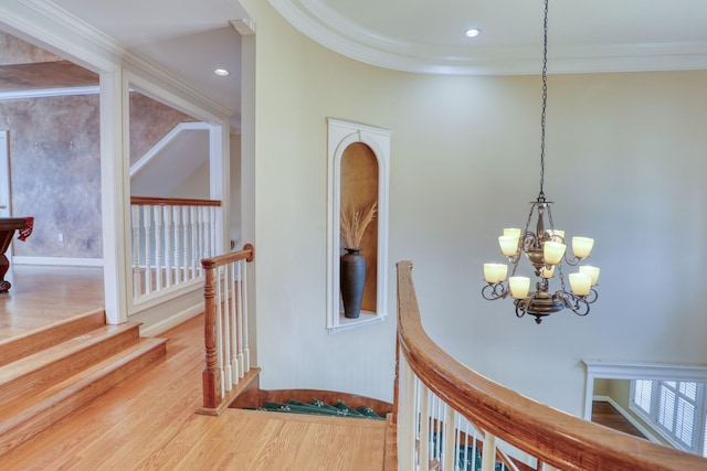 corridor featuring ornamental molding, wood finished floors, and an upstairs landing