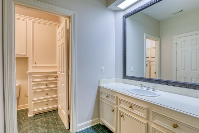 bathroom featuring visible vents, vanity, baseboards, and tile patterned floors