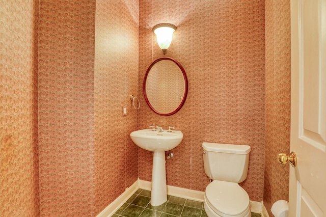 bathroom featuring baseboards, tile patterned floors, toilet, and wallpapered walls