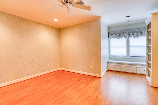 spare room featuring ceiling fan, visible vents, baseboards, light wood-type flooring, and crown molding