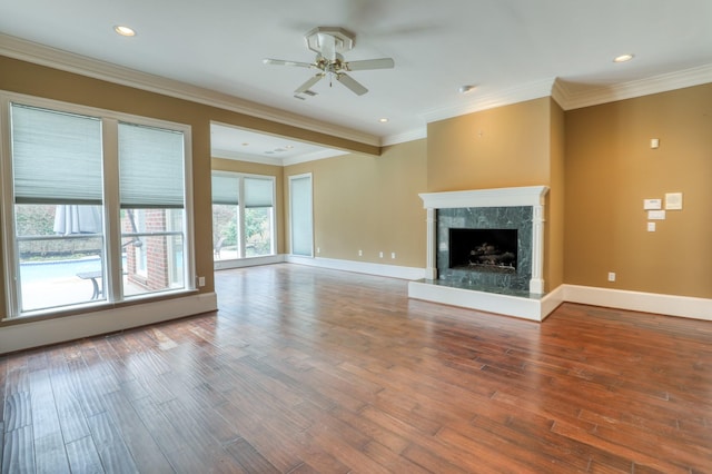 unfurnished living room with ornamental molding, a fireplace, wood finished floors, and baseboards