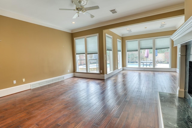 unfurnished room with baseboards, visible vents, wood finished floors, and a high end fireplace