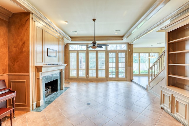 living area with ceiling fan, stairway, and crown molding