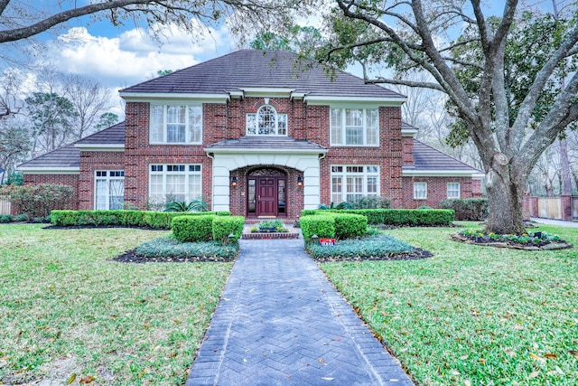 colonial home with a front lawn and brick siding