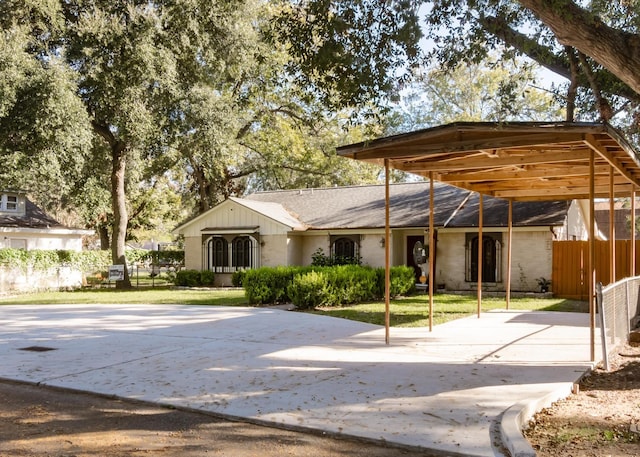 exterior space with a carport, driveway, a yard, and fence