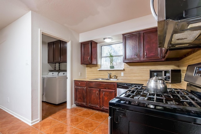 kitchen with stainless steel appliances, tasteful backsplash, light countertops, a sink, and washer and dryer