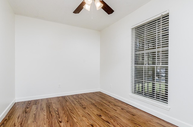 spare room with a ceiling fan, baseboards, and wood finished floors