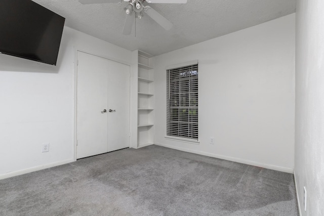 unfurnished bedroom with a textured ceiling, a closet, carpet flooring, and baseboards