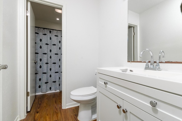 full bathroom featuring toilet, a shower with shower curtain, wood finished floors, and vanity