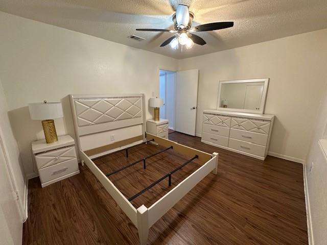 bedroom featuring a textured ceiling, wood finished floors, a ceiling fan, visible vents, and baseboards