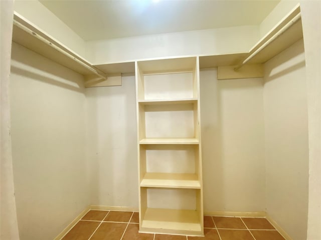 walk in closet featuring dark tile patterned floors