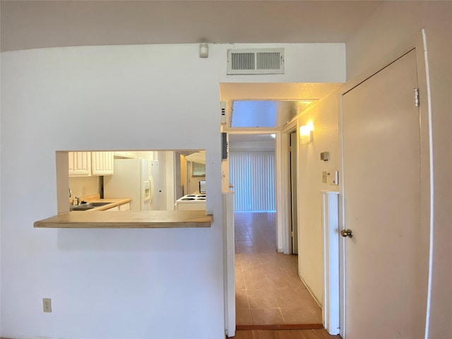 corridor featuring visible vents and a sink