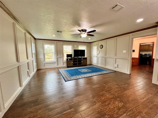 unfurnished living room with dark wood-type flooring, a decorative wall, visible vents, and ornamental molding