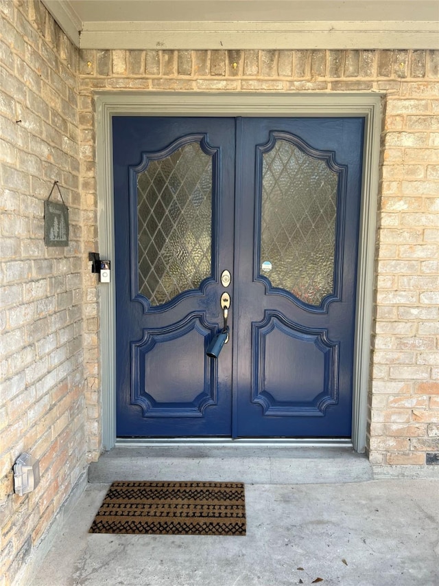 view of exterior entry featuring brick siding