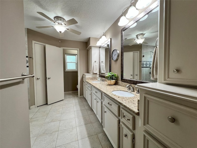 bathroom with tile patterned floors, toilet, a textured ceiling, and a sink