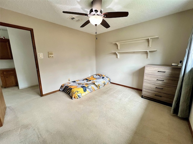 unfurnished bedroom with visible vents, light carpet, a textured ceiling, and baseboards