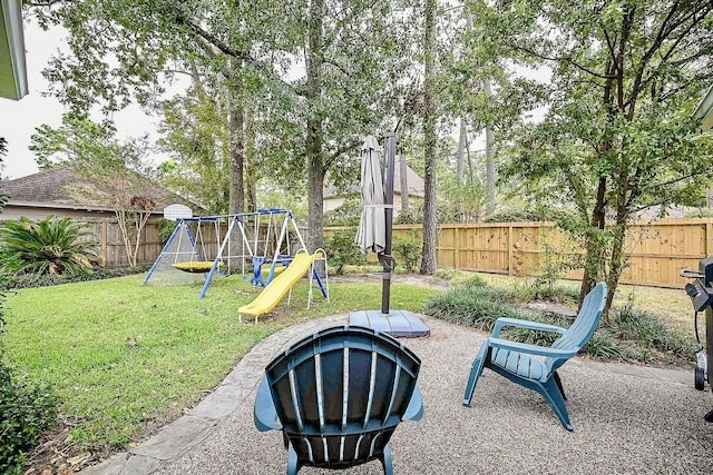 view of yard with a patio, a playground, and a fenced backyard