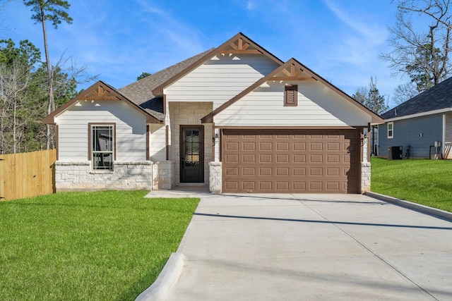 view of front facade featuring concrete driveway, an attached garage, a front yard, fence, and stone siding