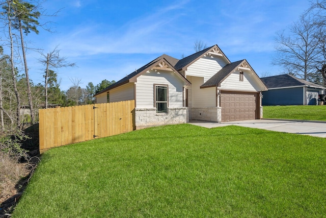 view of front facade with an attached garage, a front yard, fence, stone siding, and driveway