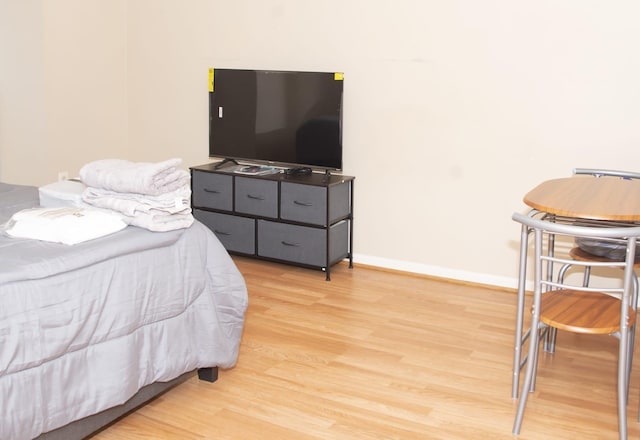 bedroom with light wood-style flooring and baseboards