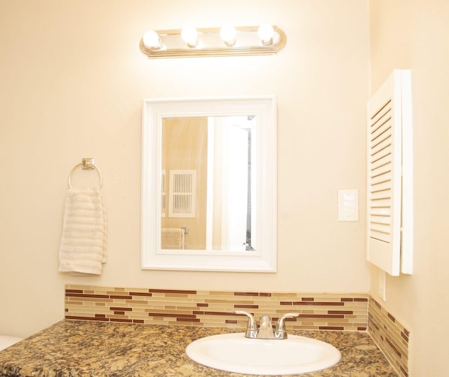 bathroom with vanity and decorative backsplash