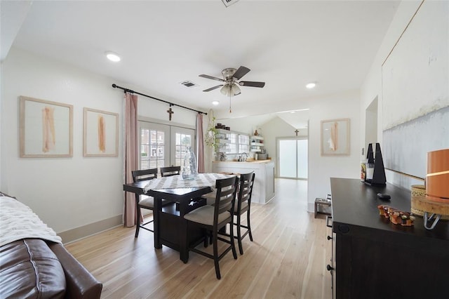 dining room featuring french doors, light wood finished floors, visible vents, ceiling fan, and baseboards