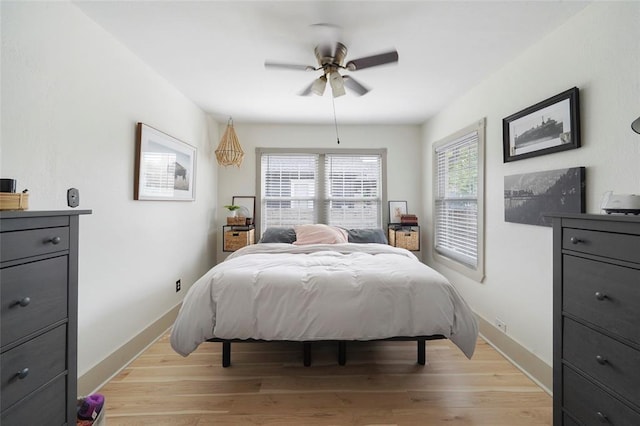 bedroom with light wood-style flooring, baseboards, and a ceiling fan