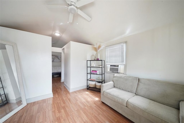 living room featuring a fireplace, light wood finished floors, ceiling fan, cooling unit, and baseboards