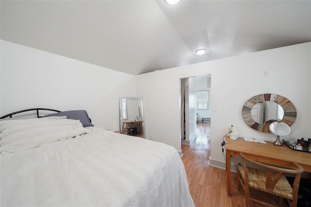 bedroom featuring lofted ceiling and light wood finished floors