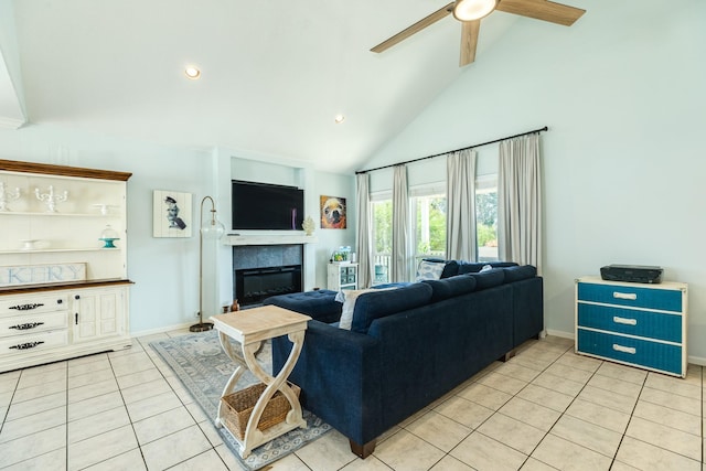 living room with light tile patterned floors, baseboards, a tile fireplace, ceiling fan, and high vaulted ceiling