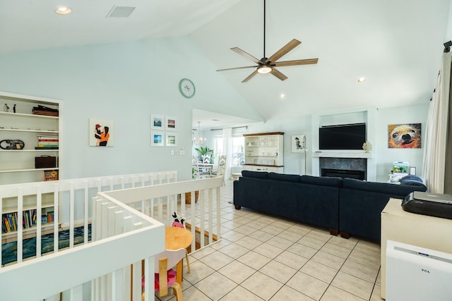 interior space featuring light tile patterned floors, recessed lighting, visible vents, a tiled fireplace, and high vaulted ceiling