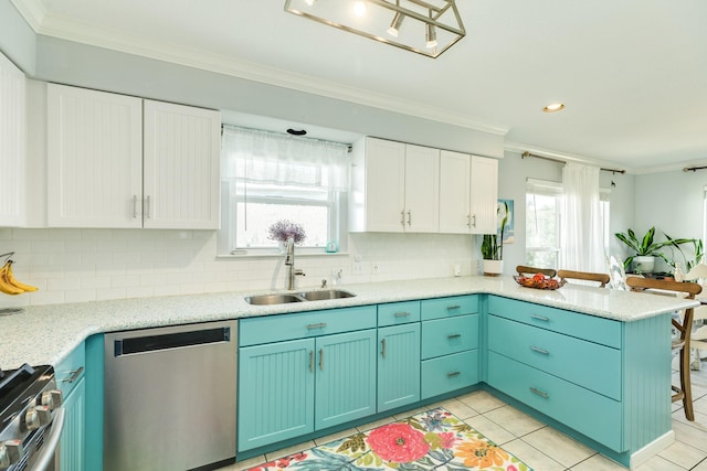 kitchen featuring plenty of natural light, ornamental molding, a peninsula, stainless steel appliances, and a sink