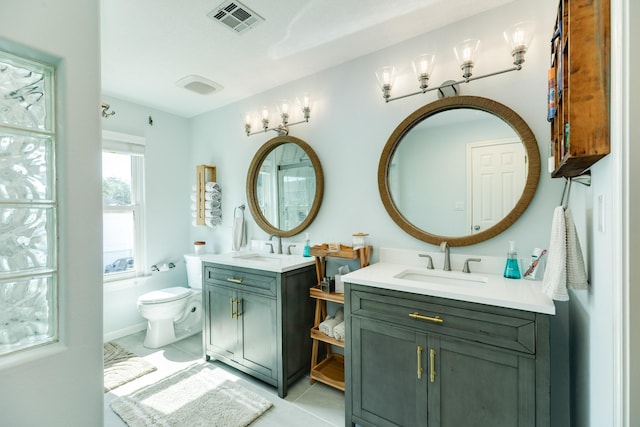 full bathroom with tile patterned flooring, toilet, two vanities, visible vents, and a sink