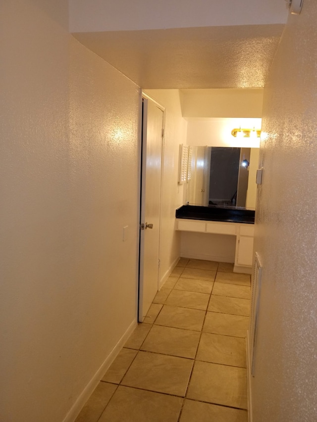 bathroom with baseboards, a textured ceiling, and tile patterned floors